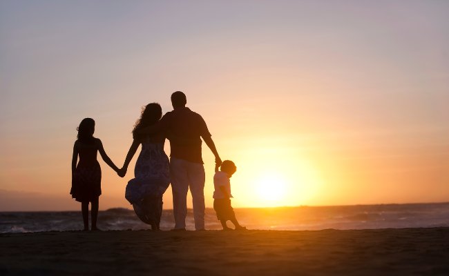 Family Enjoying At The Beach. Sunset Time. Get Life Insurance In Edmonton